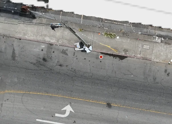 Aerial view of the reported dumping pile on the sidewalk beside a leaning utility pole